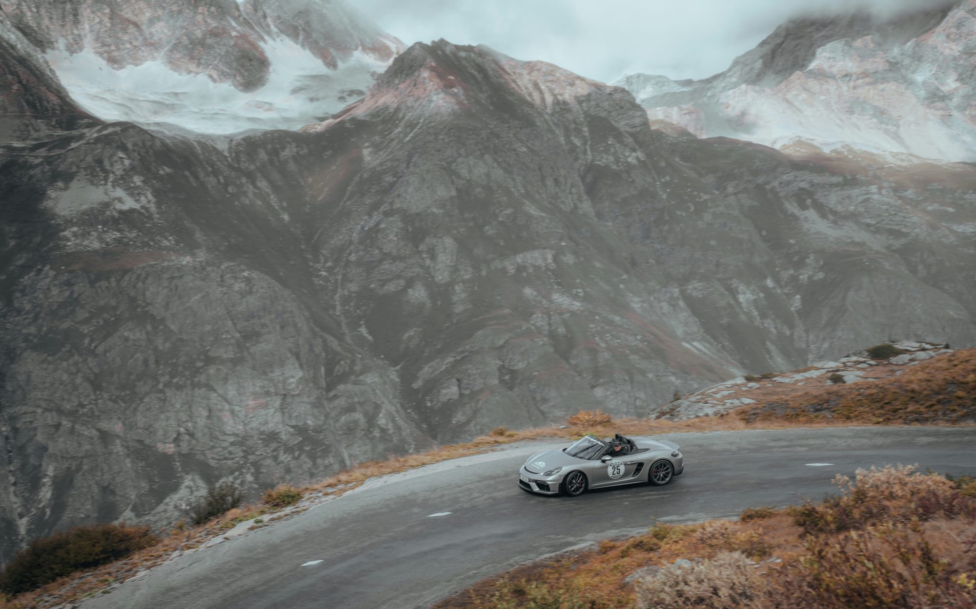 Porsche Boxster Spyder grise sur une route de col en montagne